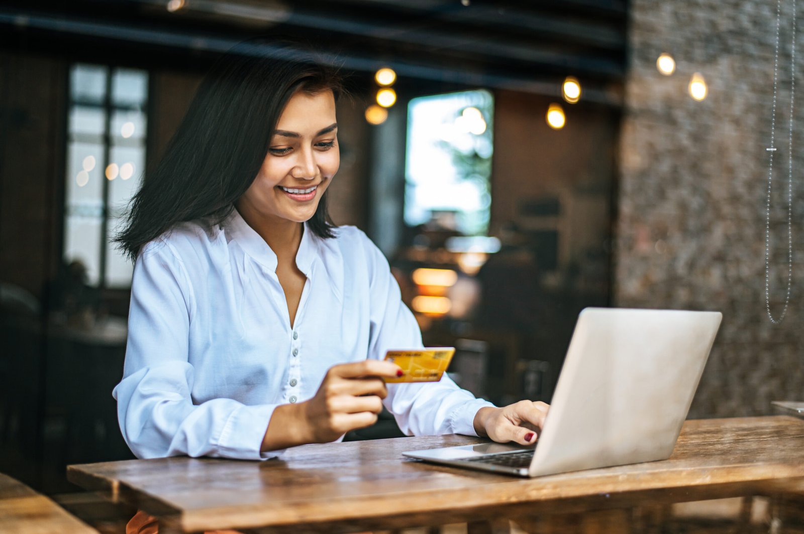 woman sat with laptop paid with credit card cafe 1 scaled
