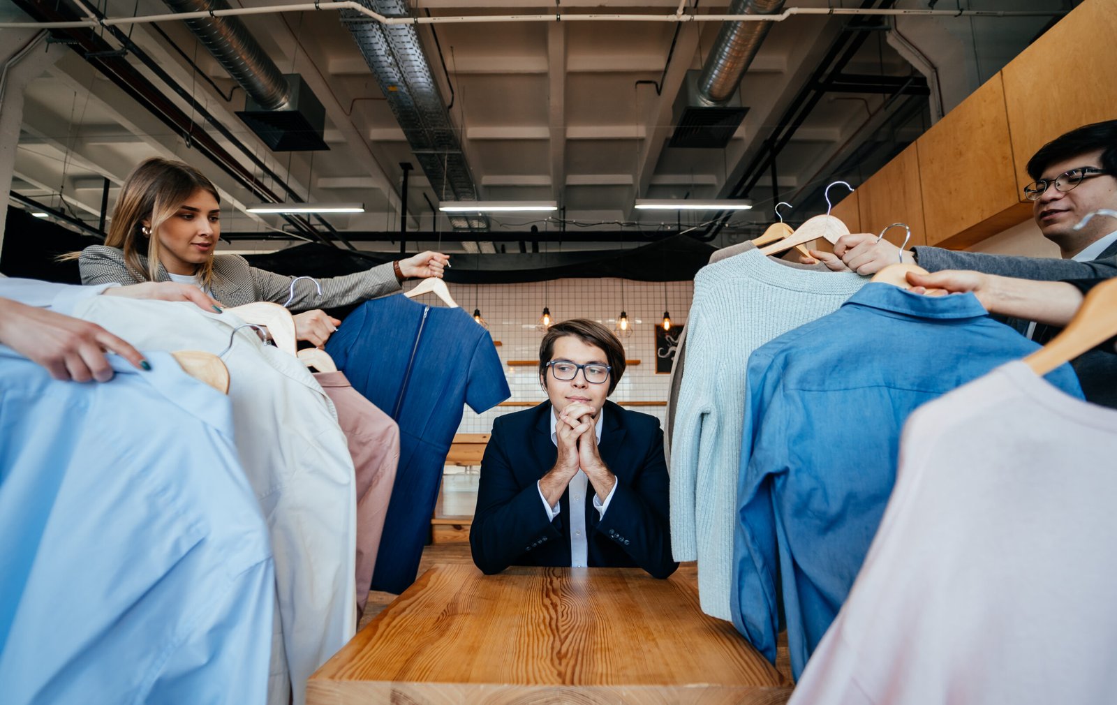 young stylist looking through set shirts fashion shooting scaled